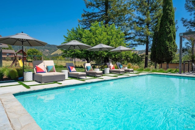 view of swimming pool with a fenced in pool, fence, and a patio