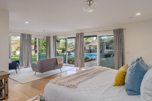 bedroom with light wood finished floors, access to exterior, and recessed lighting