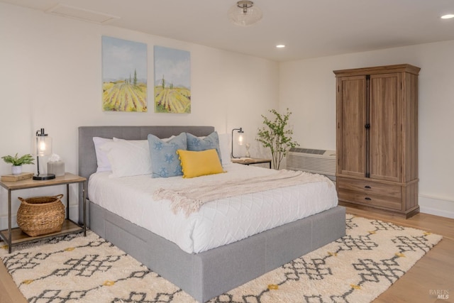 bedroom with baseboards, wood finished floors, and recessed lighting