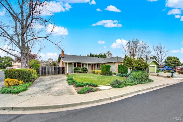 ranch-style home featuring a chimney, fence, concrete driveway, and a front yard