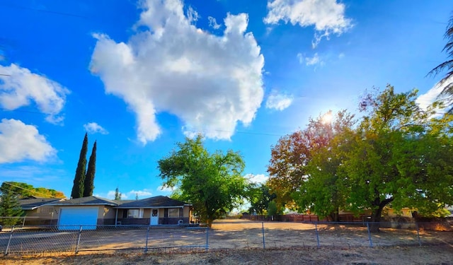 ranch-style house with a garage, driveway, and a fenced front yard