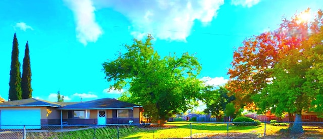 exterior space with a fenced front yard, a front yard, and an attached garage