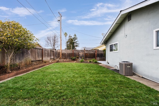 view of yard with a fenced backyard and central AC