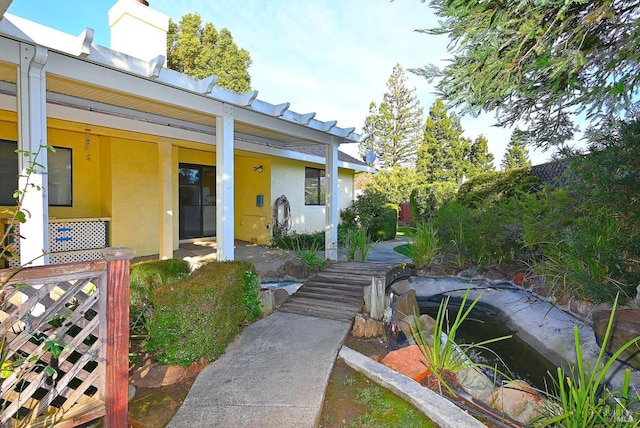 doorway to property with a chimney and stucco siding