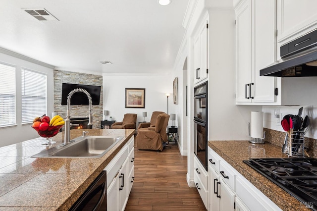 kitchen with tile countertops, black appliances, a sink, and visible vents