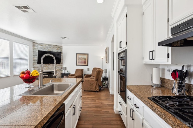 kitchen with black appliances, visible vents, tile counters, and a sink