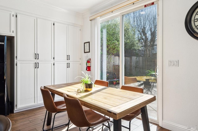 dining room featuring baseboards, crown molding, and wood finished floors