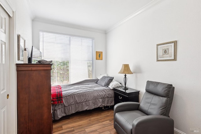 bedroom featuring wood finished floors and crown molding