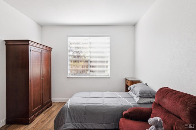 bedroom with light wood-type flooring and baseboards