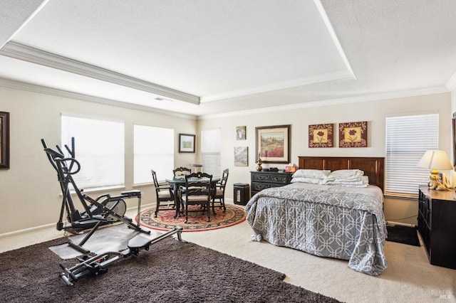 carpeted bedroom featuring ornamental molding, a tray ceiling, and multiple windows