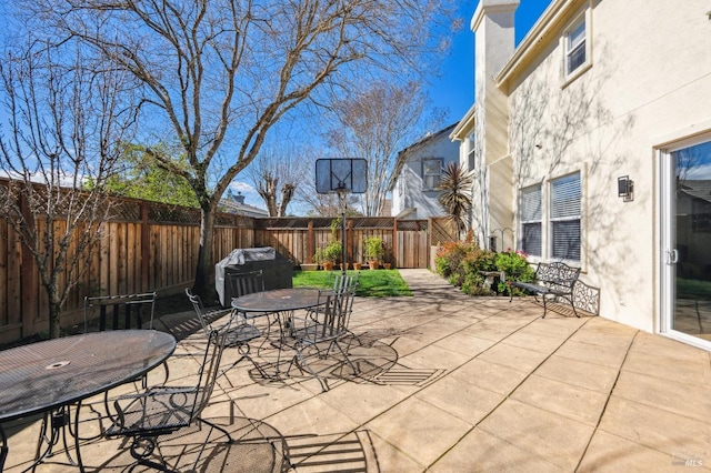 view of patio featuring outdoor dining area, grilling area, and a fenced backyard