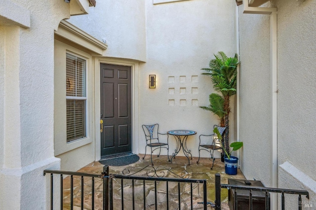 doorway to property featuring stucco siding