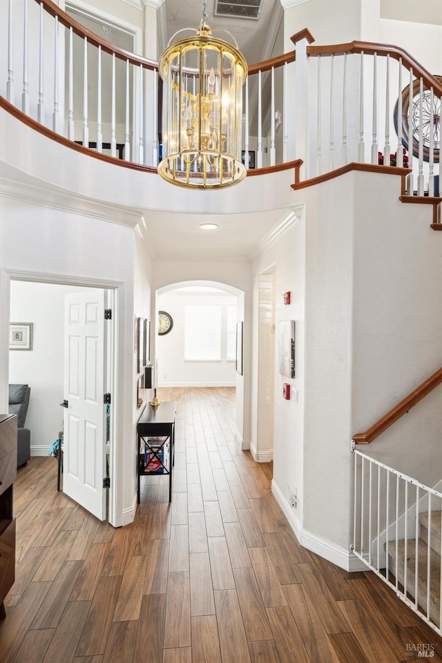 foyer entrance featuring a high ceiling, stairway, and wood finished floors