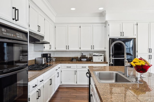 kitchen with tasteful backsplash, ornamental molding, white cabinets, under cabinet range hood, and black appliances