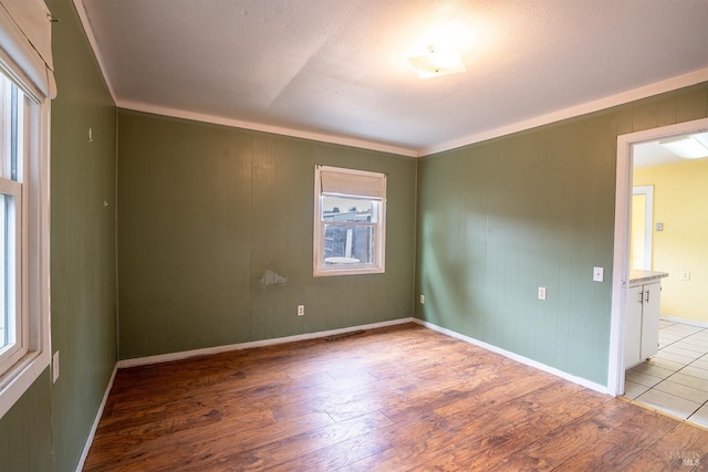 unfurnished room with baseboards and wood finished floors