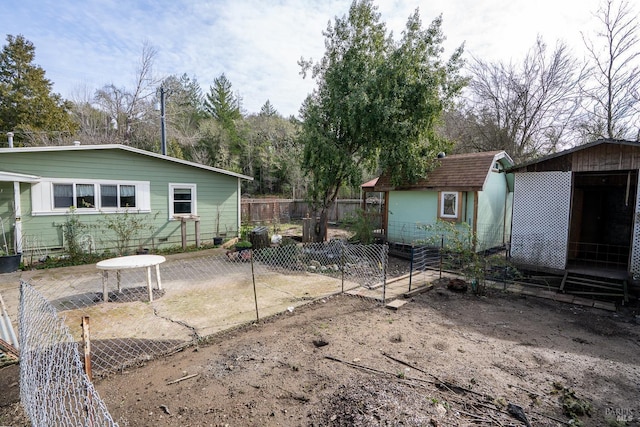 rear view of property with a patio area, a storage shed, fence, and an outdoor structure