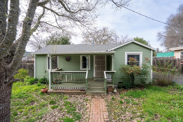 view of front of property featuring roof with shingles, a porch, crawl space, and fence