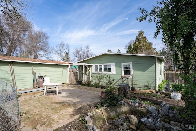 rear view of house with a patio area and fence