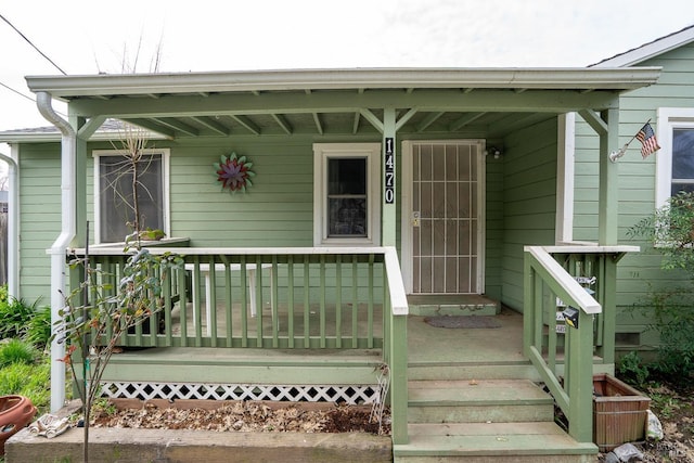 view of exterior entry featuring central air condition unit and covered porch