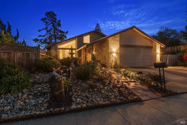 mid-century inspired home featuring a garage, concrete driveway, fence, and stucco siding