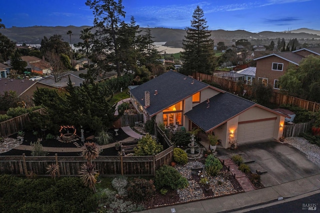 view of front of property featuring stucco siding, concrete driveway, a mountain view, a garage, and fence private yard