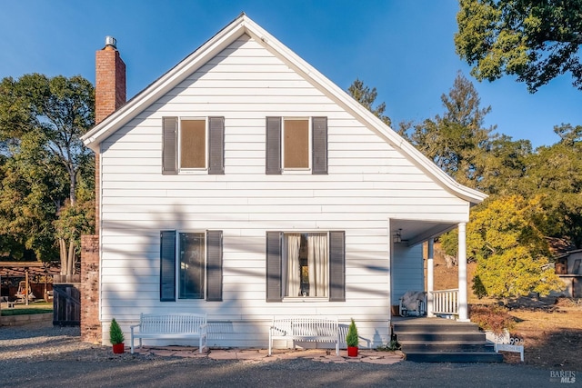 view of front of property with covered porch and a chimney