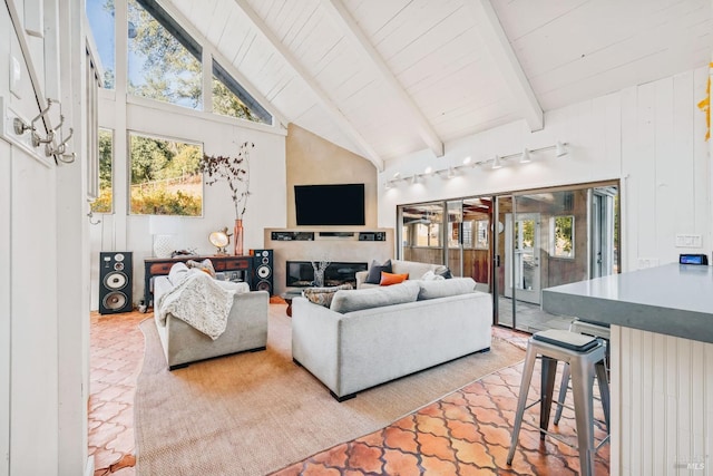 living room featuring wood ceiling, high vaulted ceiling, beamed ceiling, and a glass covered fireplace