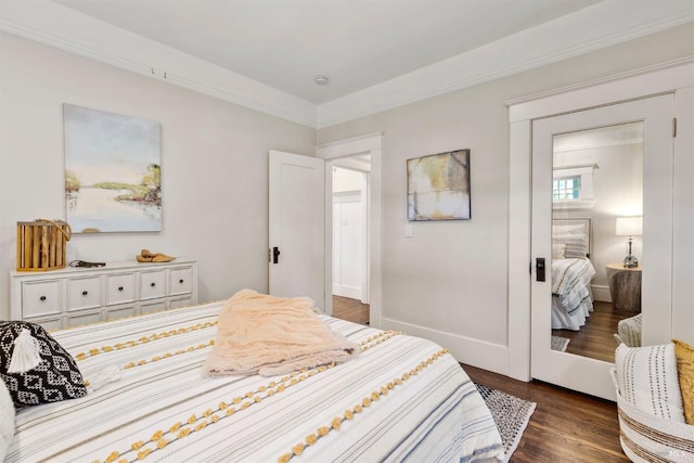 bedroom with ornamental molding, dark wood-style flooring, and baseboards