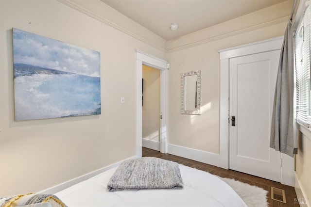 bedroom with dark wood-style floors, a closet, visible vents, and baseboards