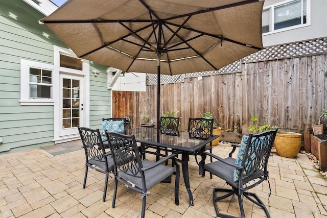 view of patio featuring outdoor dining area and fence