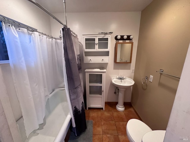full bathroom featuring toilet, a sink, baseboards, tile patterned floors, and shower / bath combination with curtain