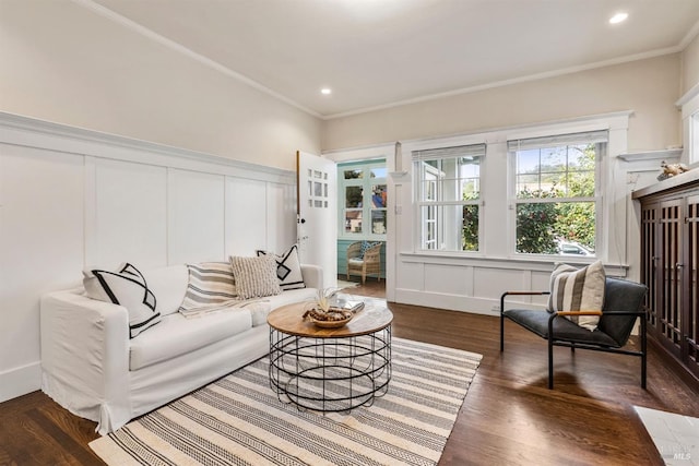 living area featuring crown molding, dark wood-style floors, and a decorative wall