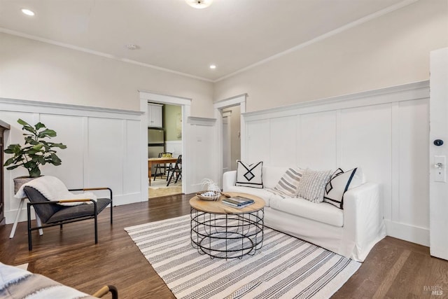 living room featuring ornamental molding, recessed lighting, dark wood finished floors, and a decorative wall