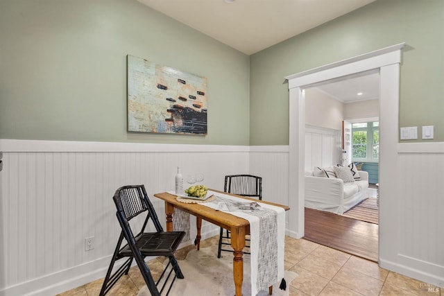 office with light tile patterned floors and a wainscoted wall