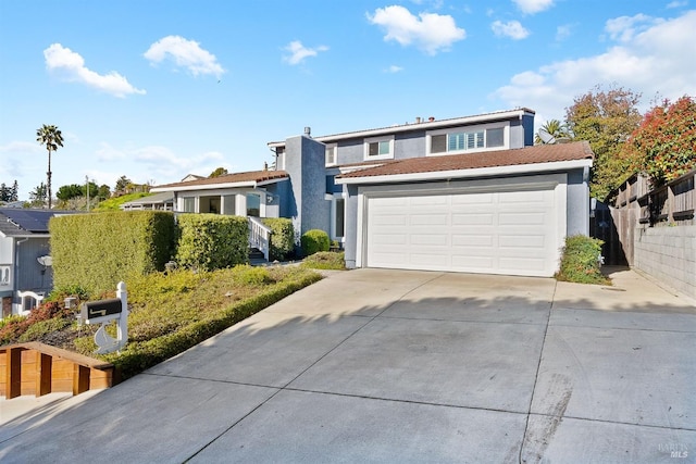 traditional home featuring driveway, a tile roof, a garage, and stucco siding