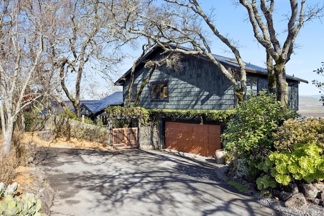 view of property exterior featuring driveway and an attached garage