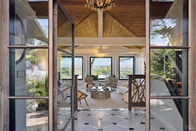 entryway featuring an inviting chandelier, high vaulted ceiling, and tile patterned floors