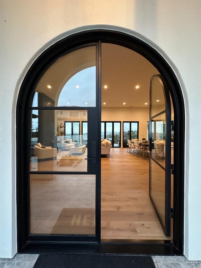 entryway featuring arched walkways, recessed lighting, and wood finished floors