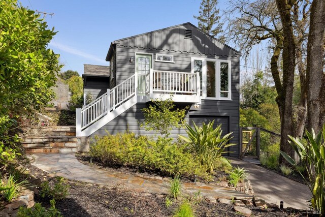 view of front facade featuring a garage, stairway, and board and batten siding