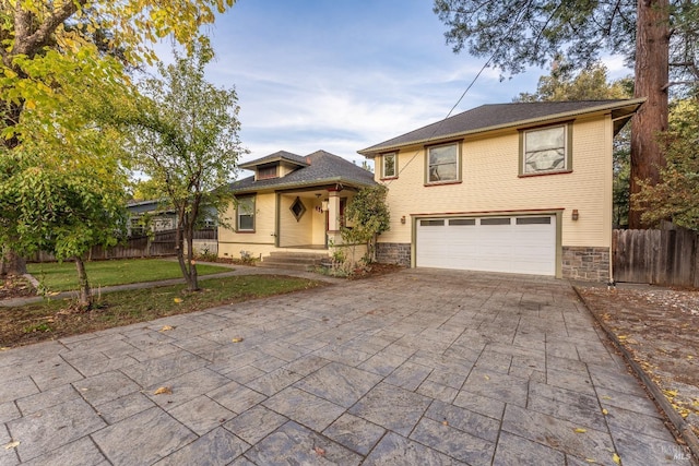 view of front facade featuring an attached garage, stone siding, fence, and decorative driveway