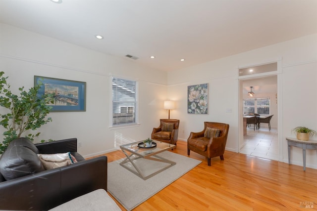 living area featuring a wealth of natural light, wood finished floors, visible vents, and recessed lighting