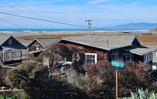 view of front of home with a shingled roof and a mountain view