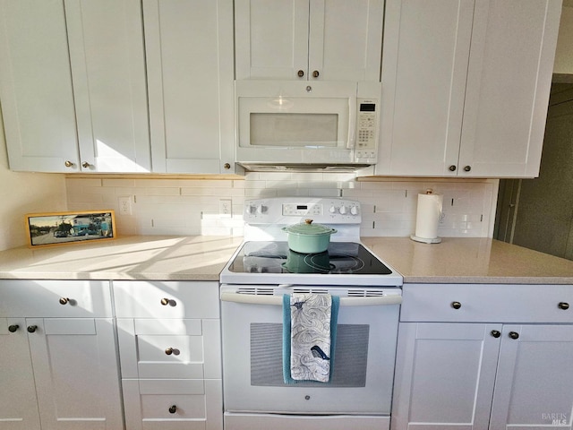 kitchen featuring white appliances, white cabinets, and decorative backsplash