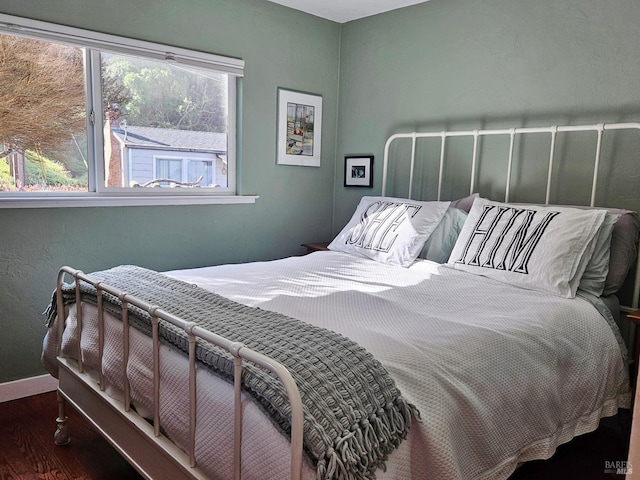 bedroom featuring dark wood finished floors and baseboards