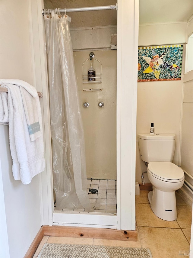 bathroom with tile patterned flooring, baseboards, a shower stall, and toilet