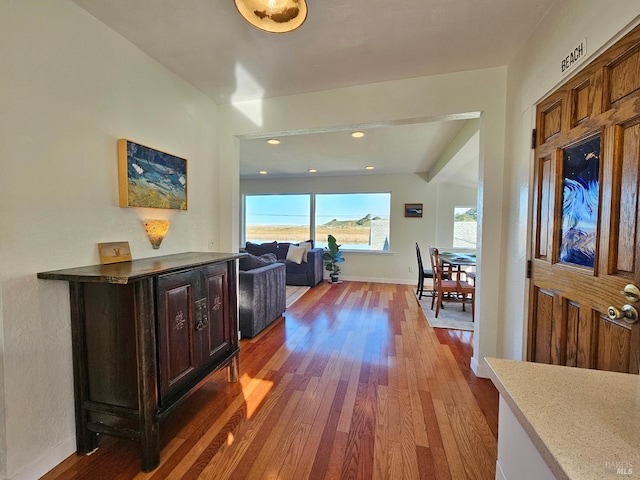 corridor with recessed lighting, wood finished floors, and baseboards