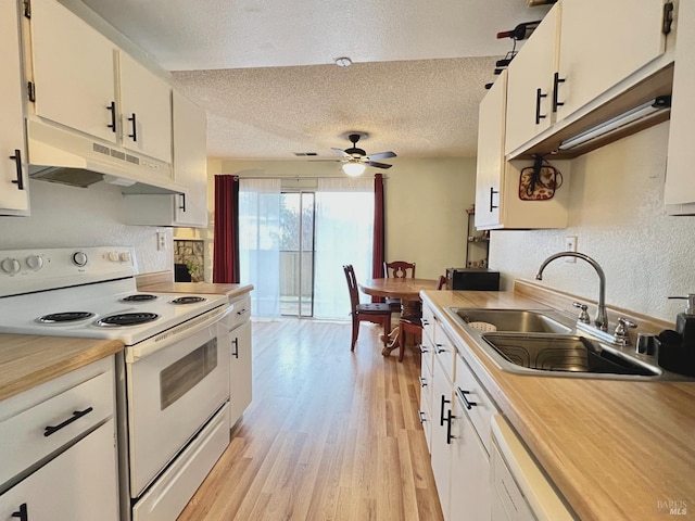 kitchen featuring electric range, light wood-style flooring, under cabinet range hood, a sink, and light countertops