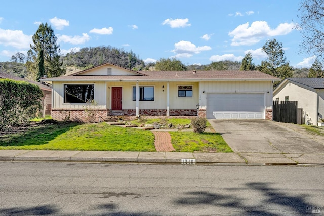 ranch-style house featuring an attached garage, a front yard, concrete driveway, and brick siding