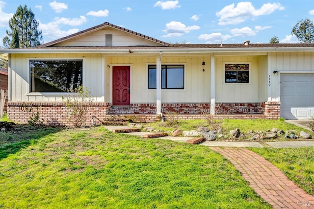 ranch-style home featuring a garage, brick siding, and board and batten siding