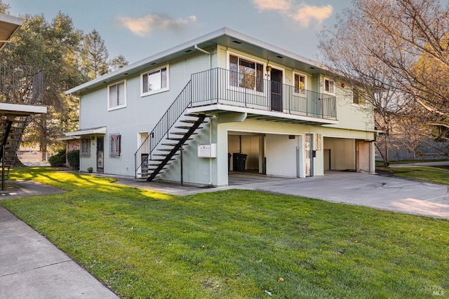 view of front of property with stairs, concrete driveway, and a front yard